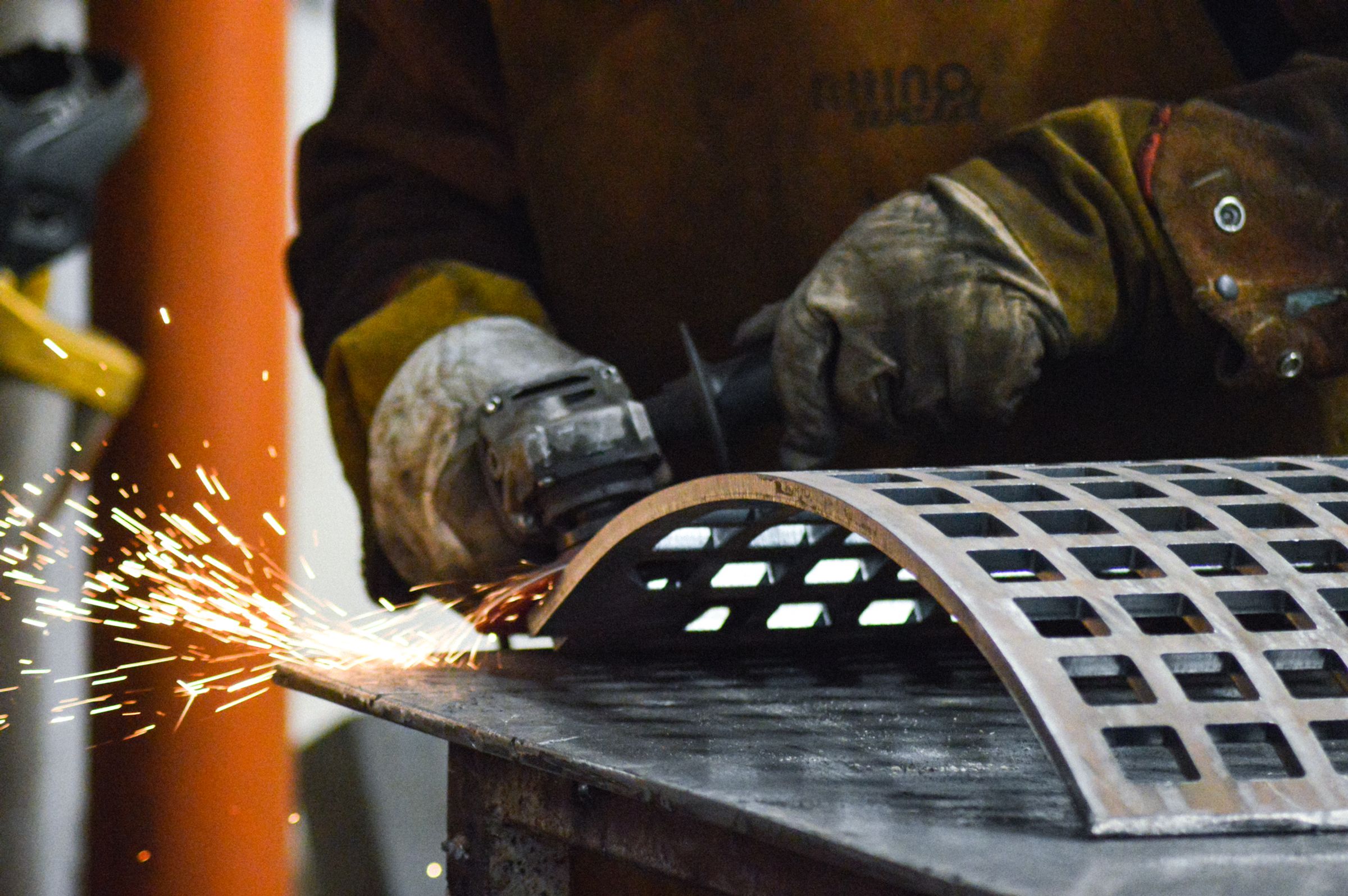 BSF fabricator grinding a Hardox recycling trommel screen