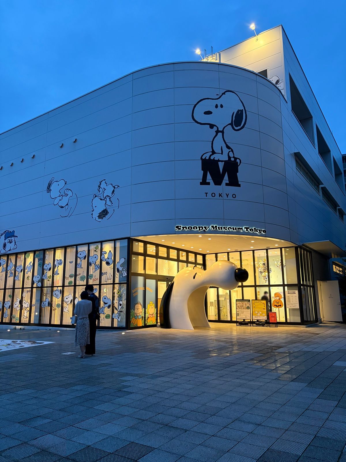 夕暮れのスヌーピーミュージアムの外観。入口にスヌーピーの顔の形のアーチがある