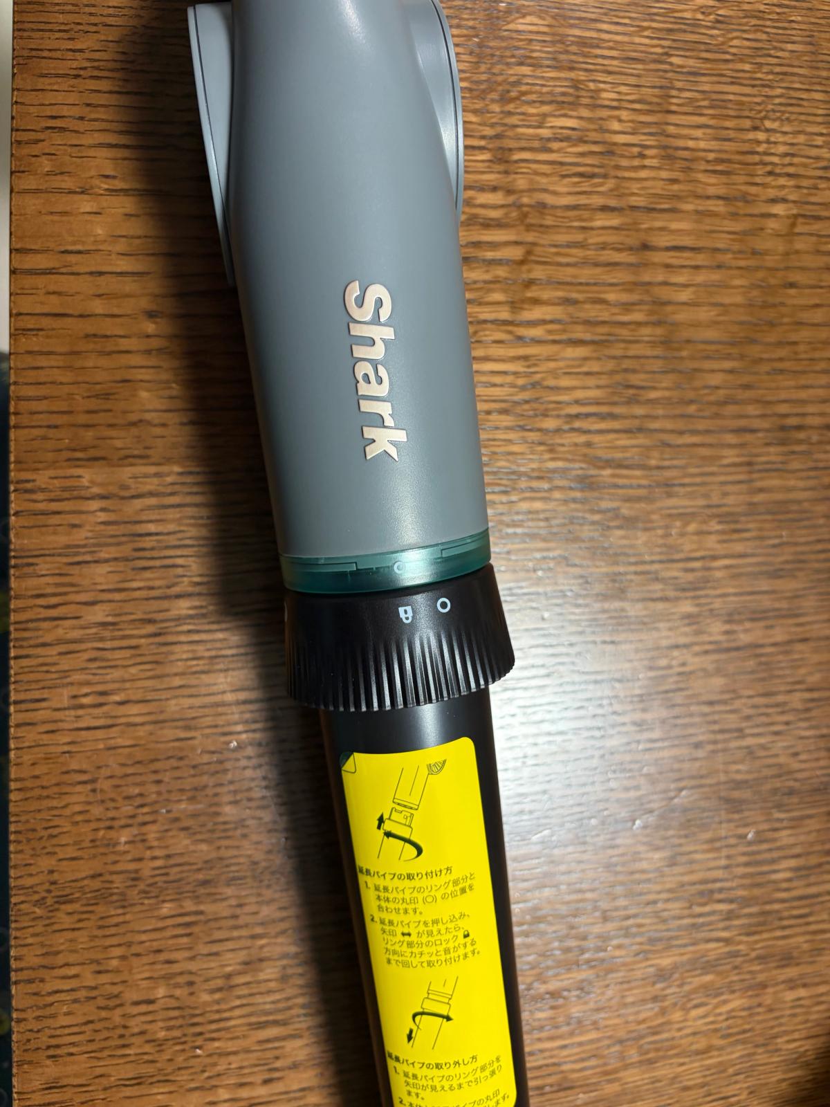 本体と延長パイプの接続部。黒いローレット加工のロックリングと、取り付け方を図示した黄色いラベル
