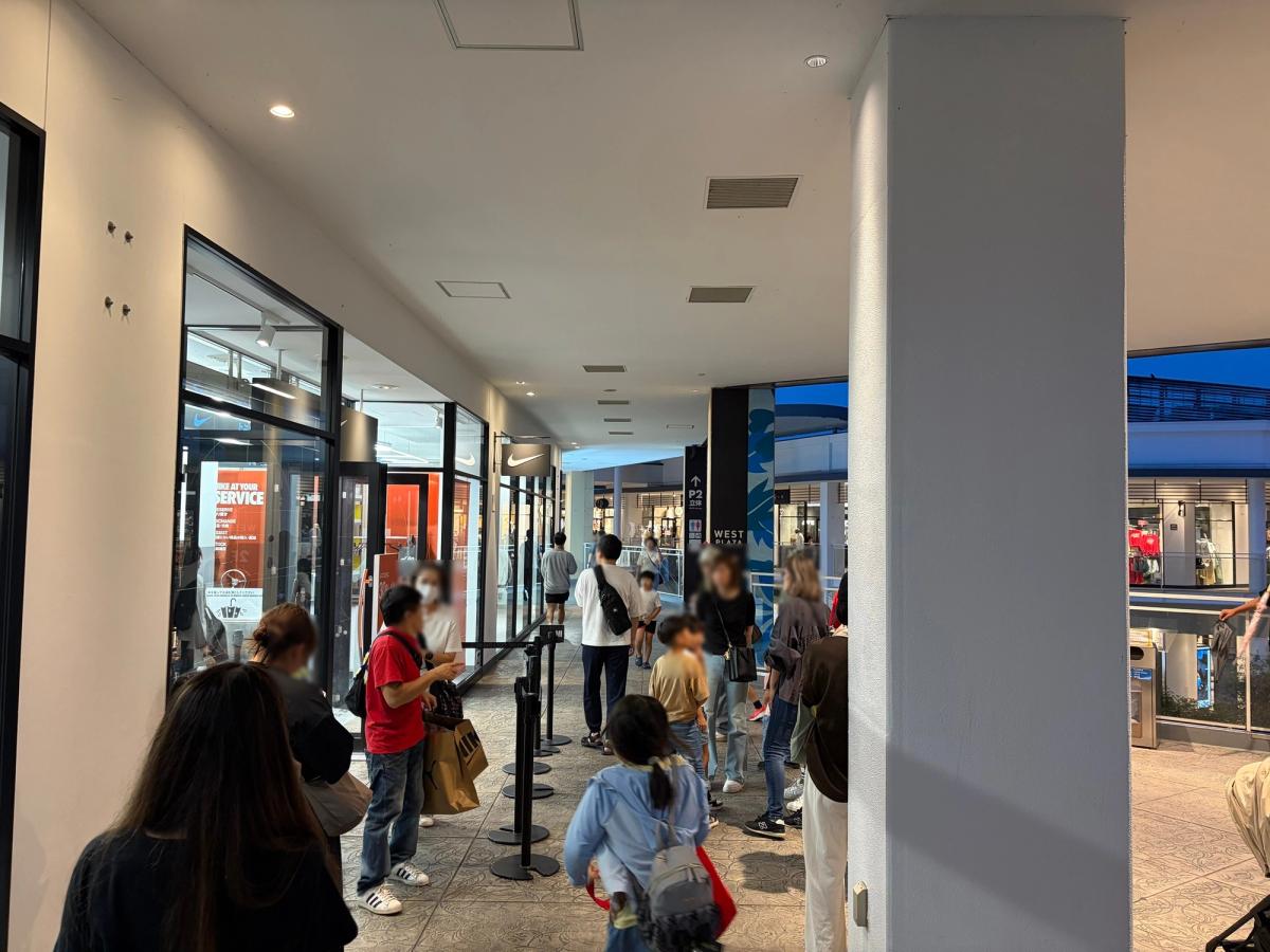 NIKEの店舗前の通路。規制ポールが並び、周囲を多くの人が歩いている