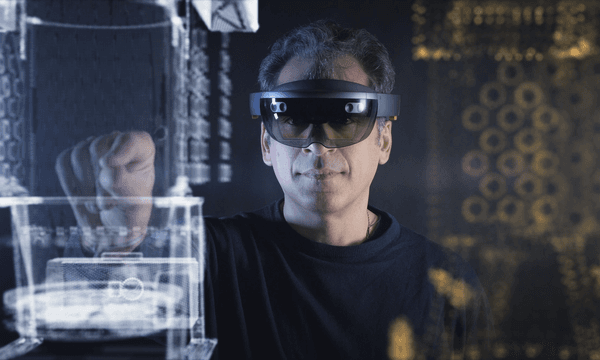 A man with AR goggles grabs a virtual structure