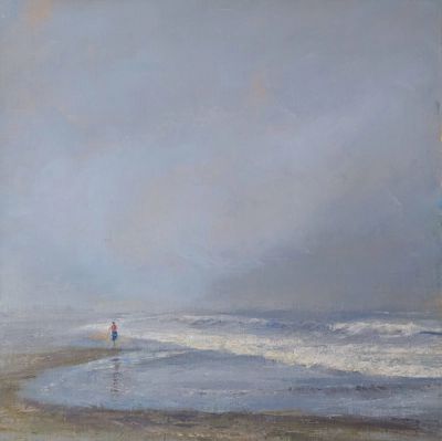 A solitary figure walking on a fog shrouded beach.