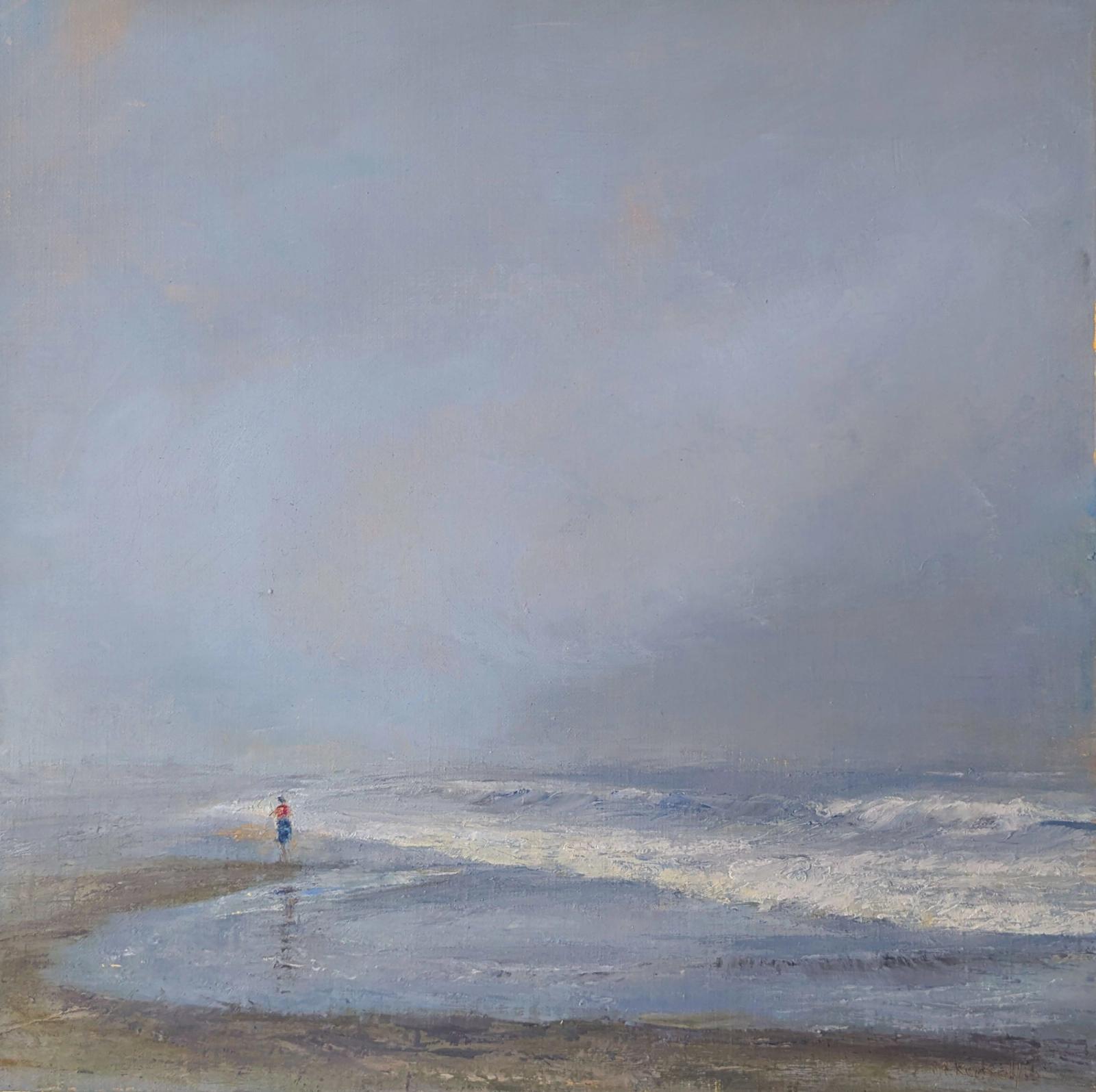 A solitary figure walking on a fog shrouded beach.