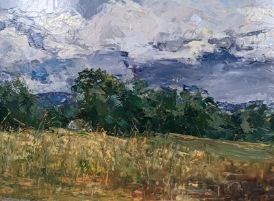 An oil painting of a ripening field in front of a tree line on a summer's day.