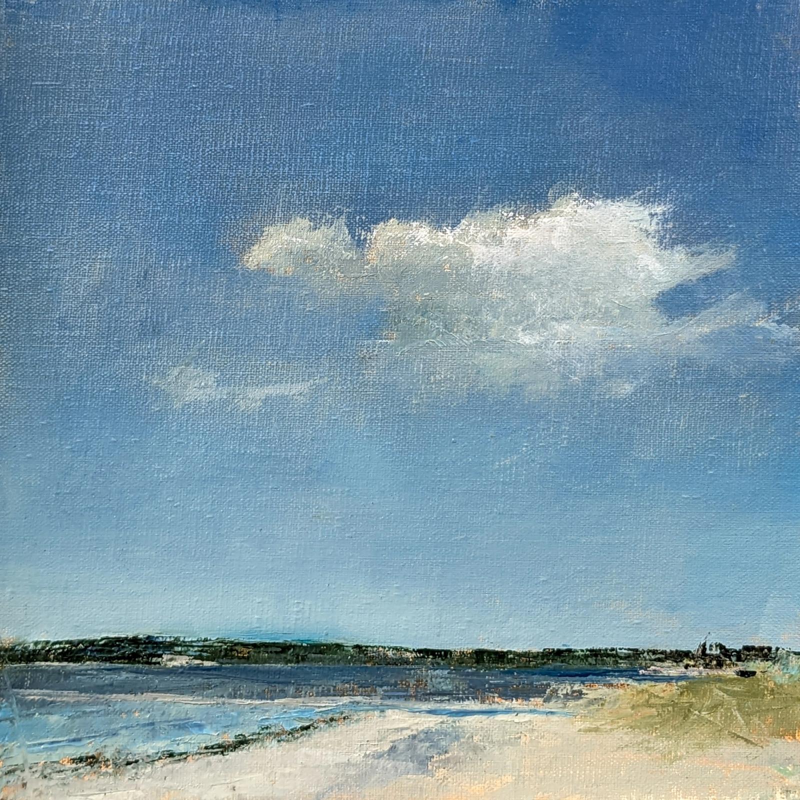 One cloud floating in a clear blue sky about a beach and distant shore.