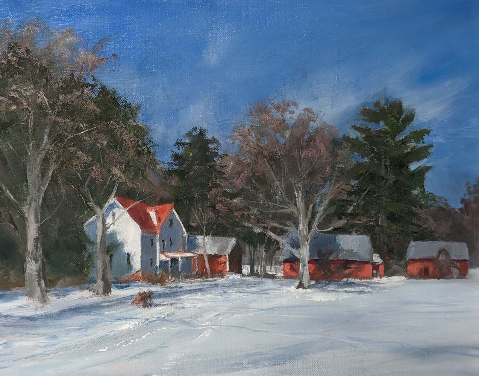 A winter scene of a white farmhouse and red barns.