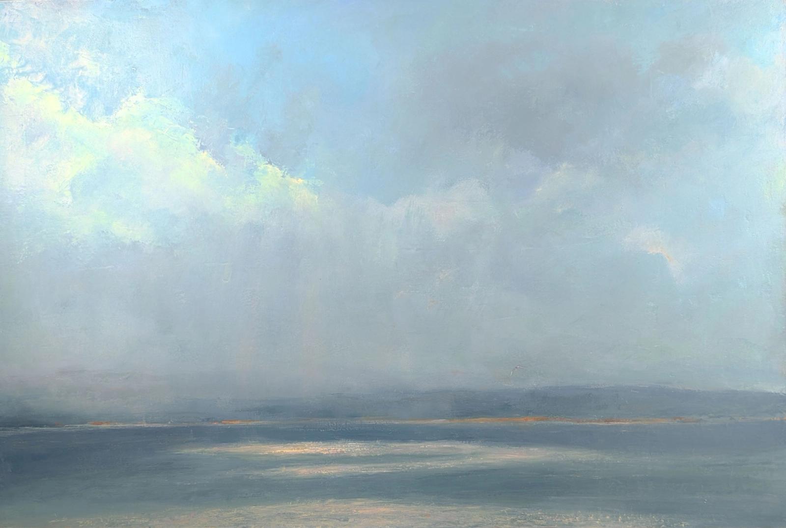 A humid summer day over the ocean with clouds and sunbreaks causing sparkling water.