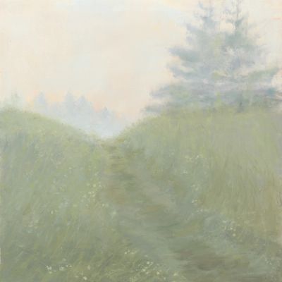 An uphill path through grass with yellow flowers on a foggy day.
