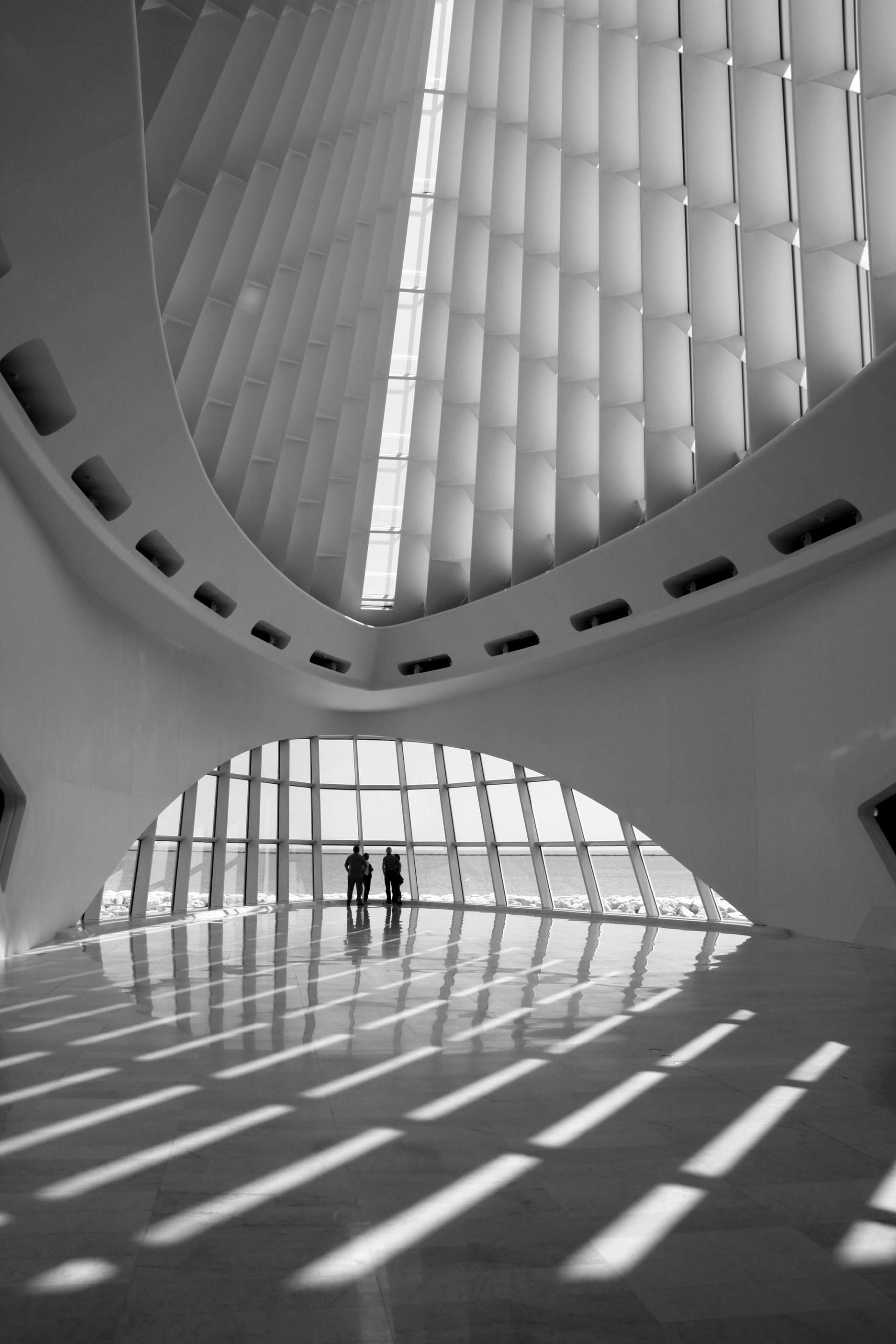 Deux personnes dans un hall d’architecture contemporaine baigné de lumière