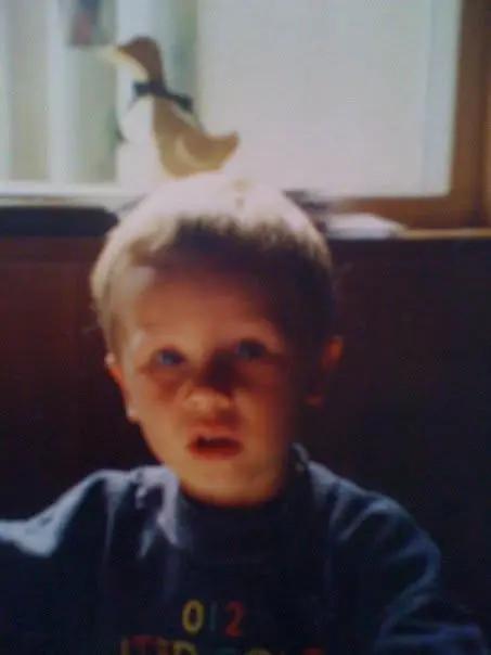 A childhood photo of a young boy at a table