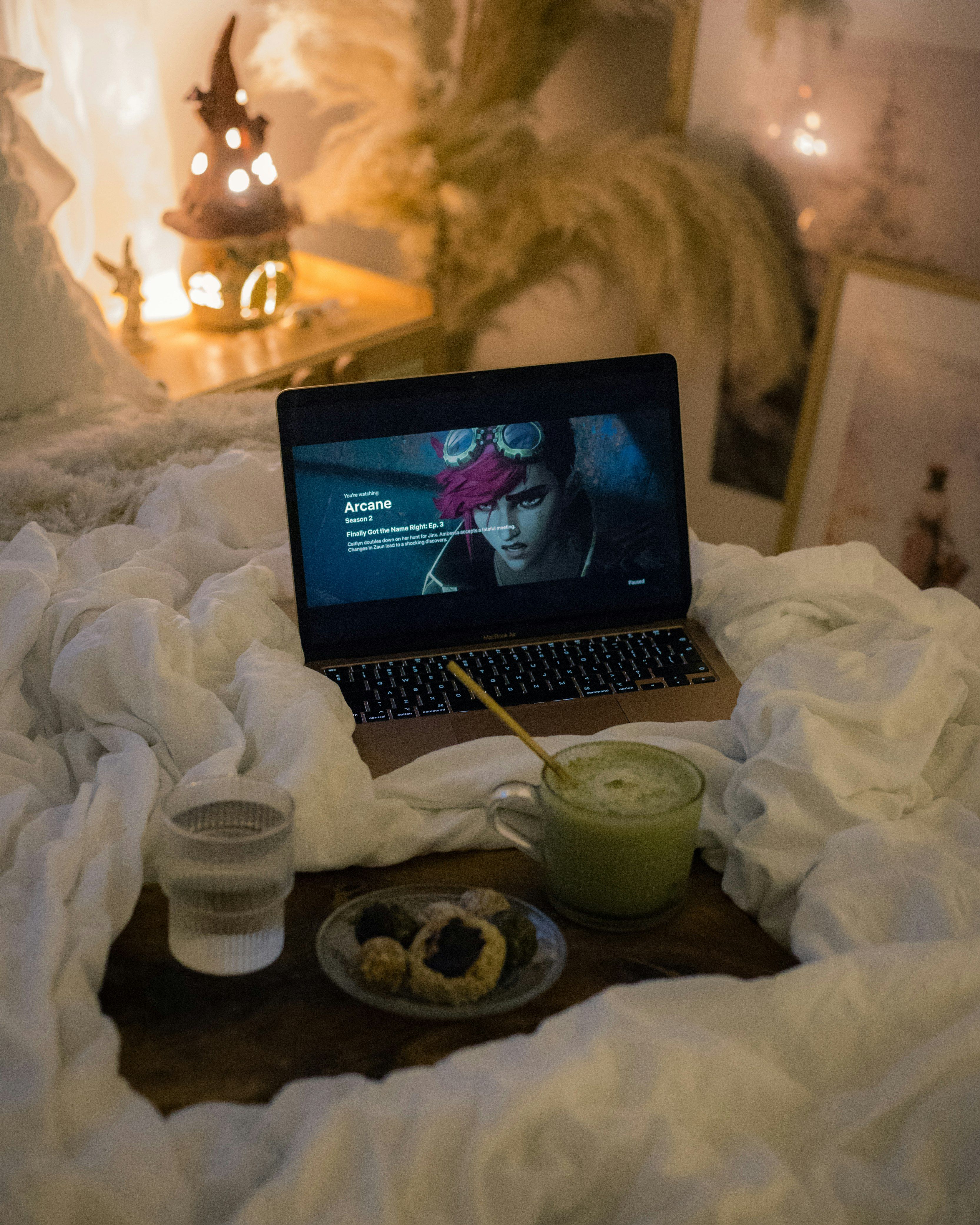 A photo of a Netflix and chill night with a laptop and snacks in a cosy atmosphere in the evening