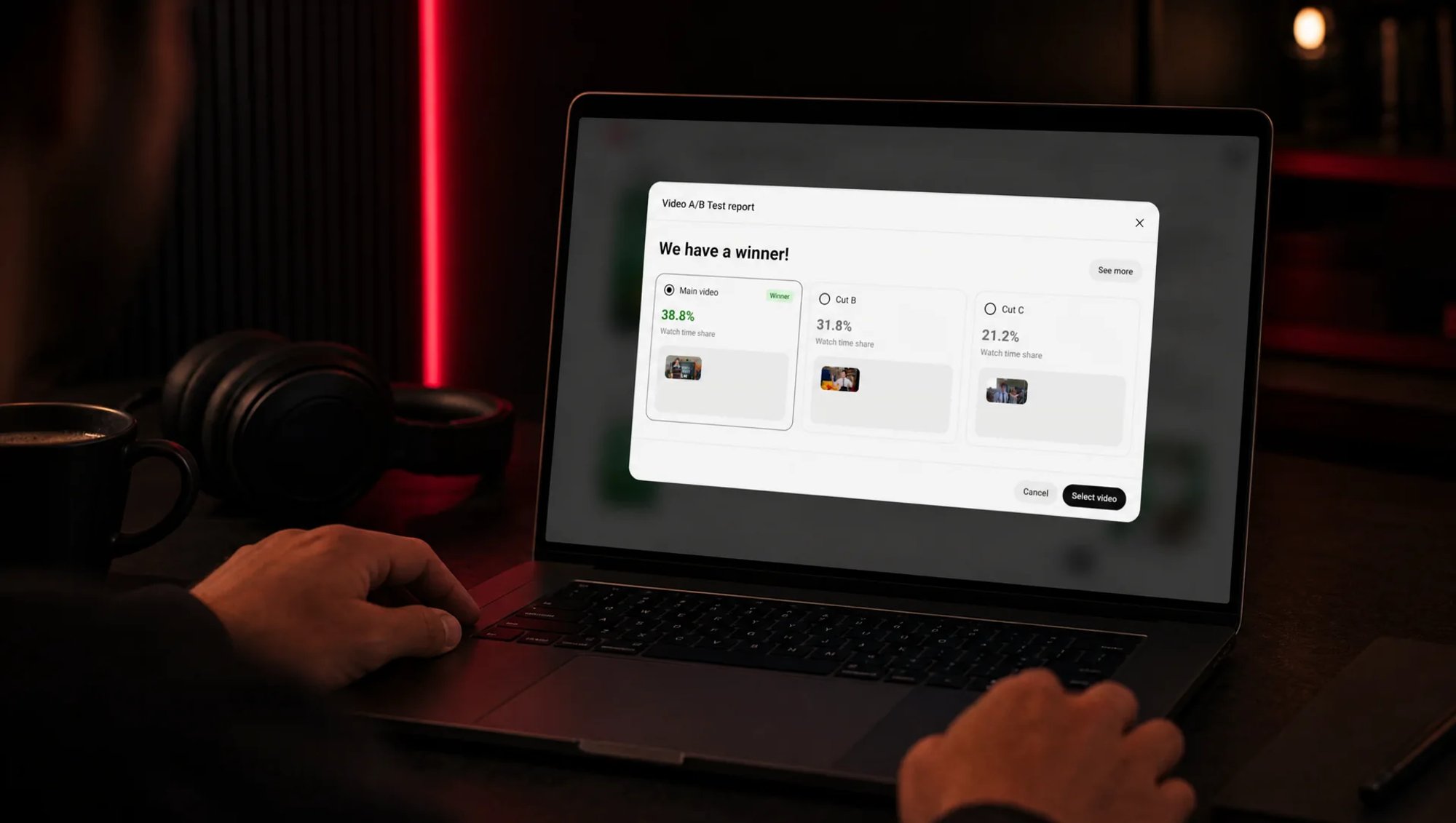 MacBook in a dark editing room lit in red, the screen showing YouTube Studio’s video A/B test report “We have a winner!” with three cuts compared, the editor’s hands on the keyboard
