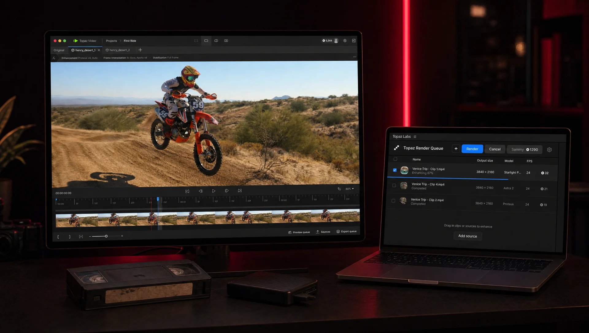 Station de montage sombre éclairée en rouge : un écran affiche Topaz Video avec un plan de motocross, un portable montre la file de rendu Topaz, une cassette VHS posée devant