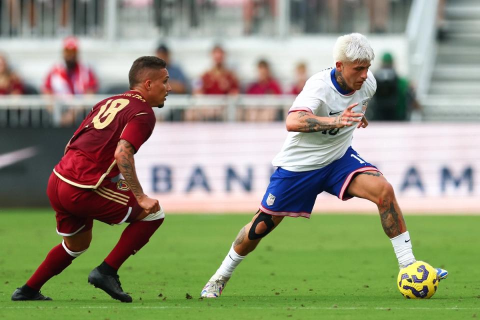 Diego Luna dribbles the ball around a Venezuelan defender