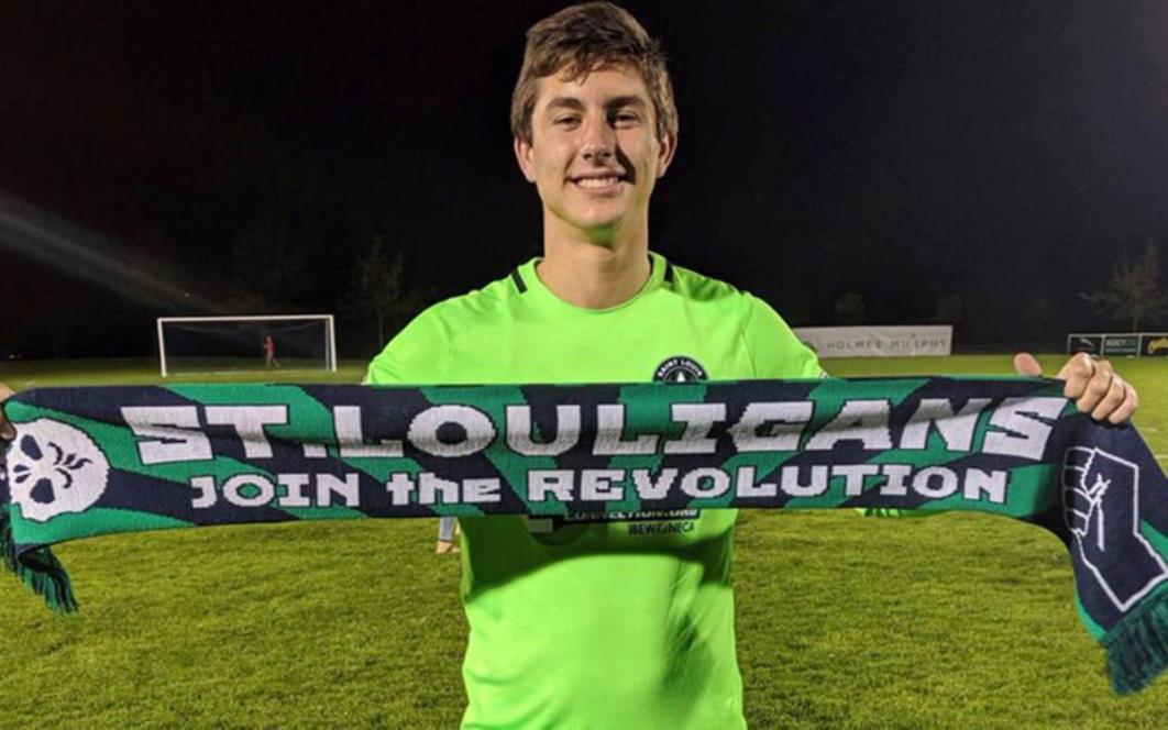 patrick schultre holding up a scarf with text "st louigans join the revolution"