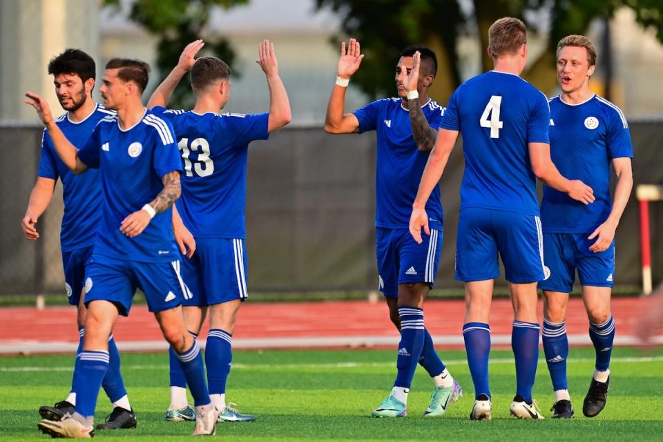 photo of teammates wearing Pancyprian blue uniforms high fiving