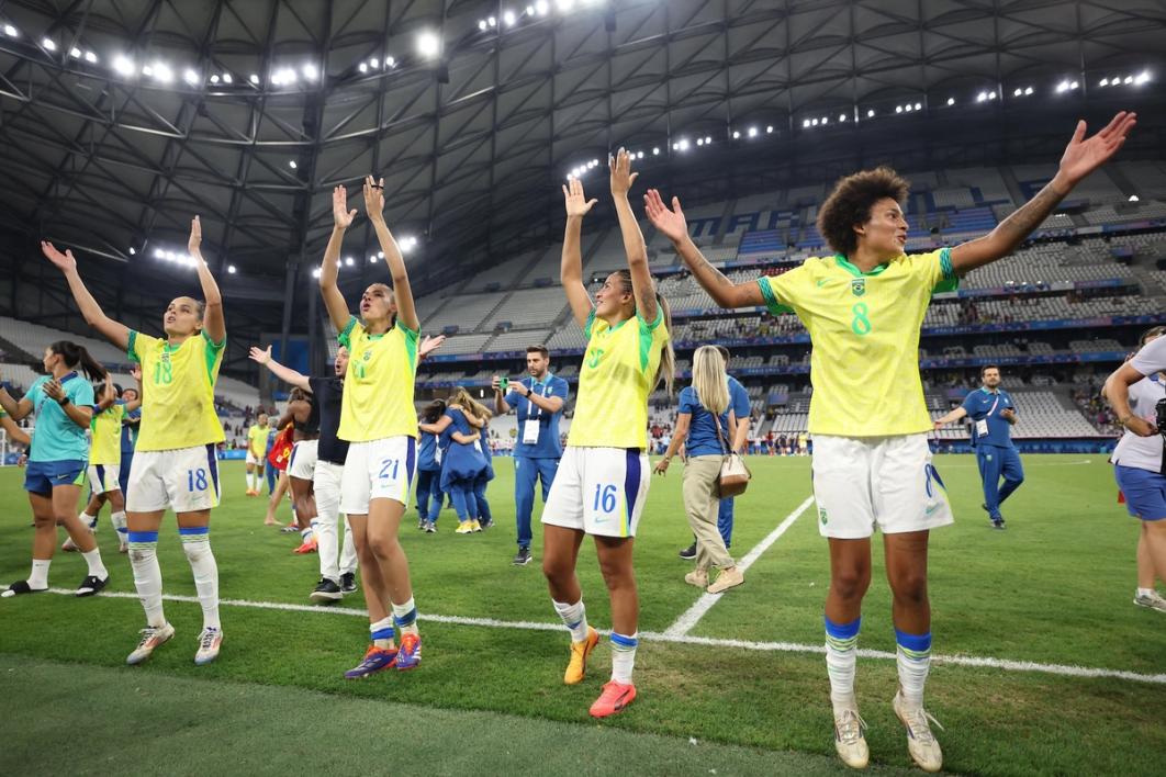 Members of the Brazil National Team jump and celebrate on the field