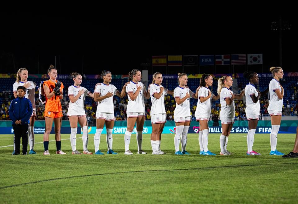 Members of the U-17 WYNT stand during the national anthem