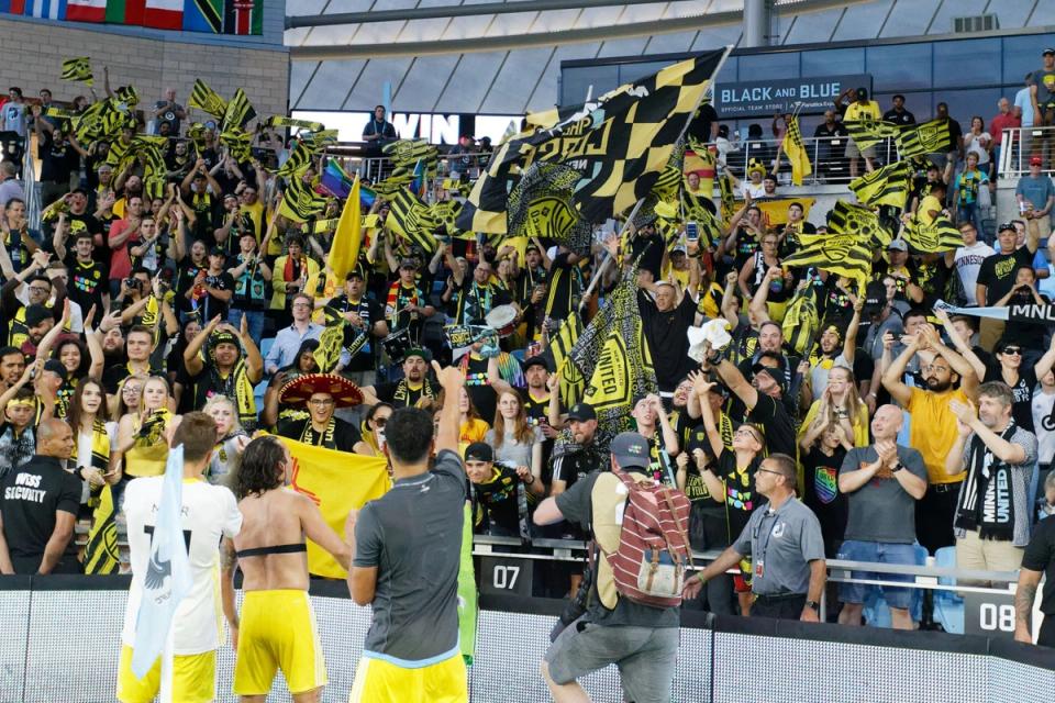 NMU players approach and celebrate with the crowd during a match