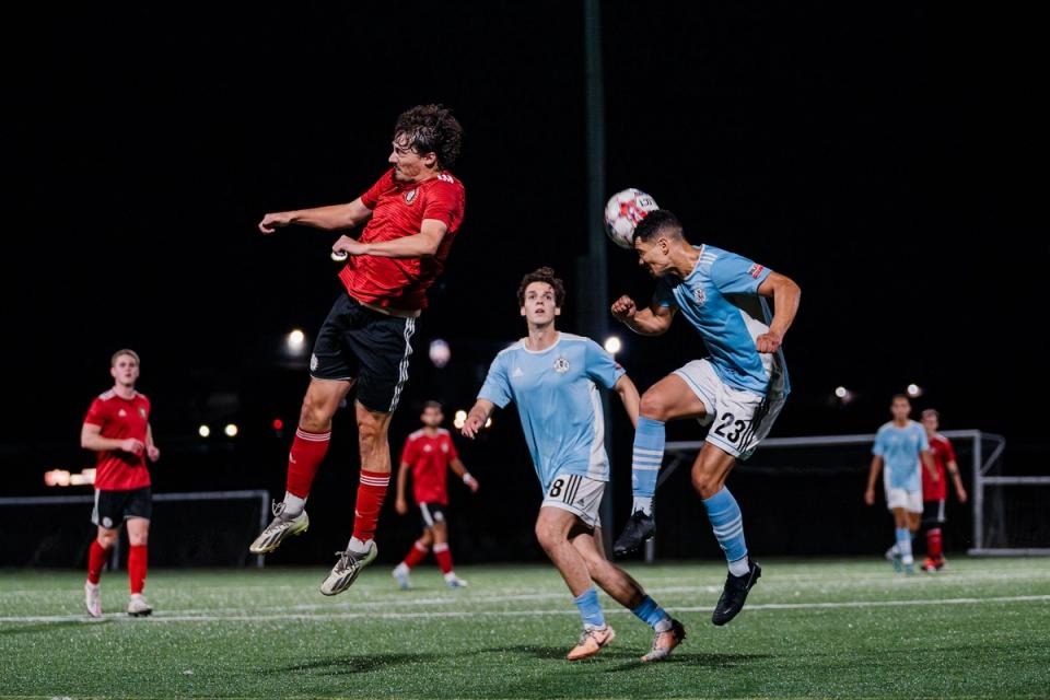 A player for West Chester United jumps up for a header