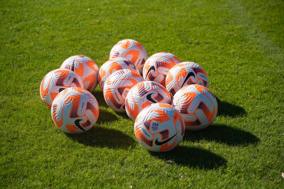 11 soccer balls on a pitch