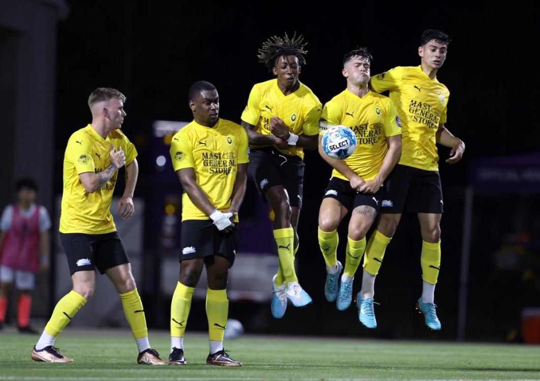 App FC players jump up for to block a free kick