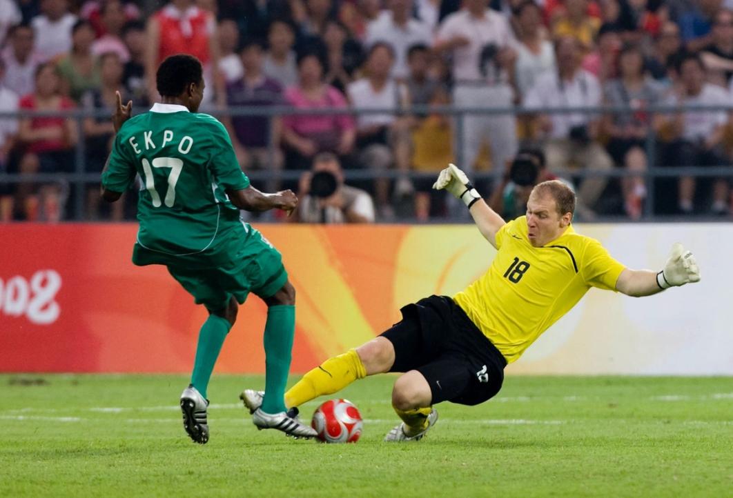 brad guzan in yellow contests a ball against an attacker in green during a 2008 olympic match