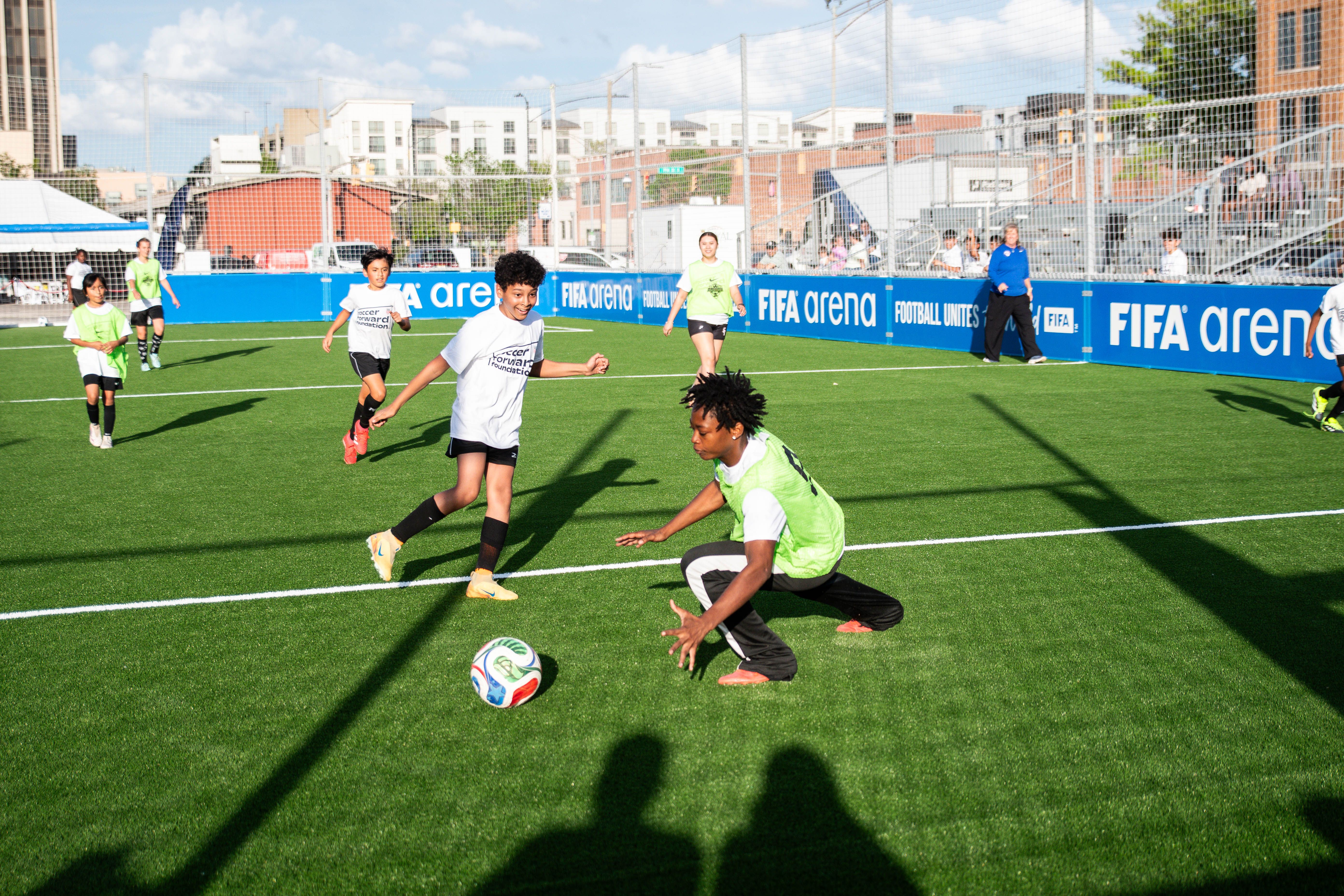 Kids playing soccer on a FIFA Arena pitch.