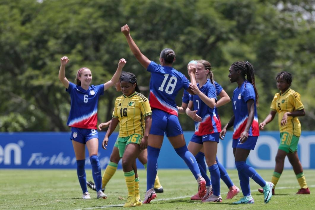 Members of the US U15 WYNT celebrate on the field after a goal against Jamaica