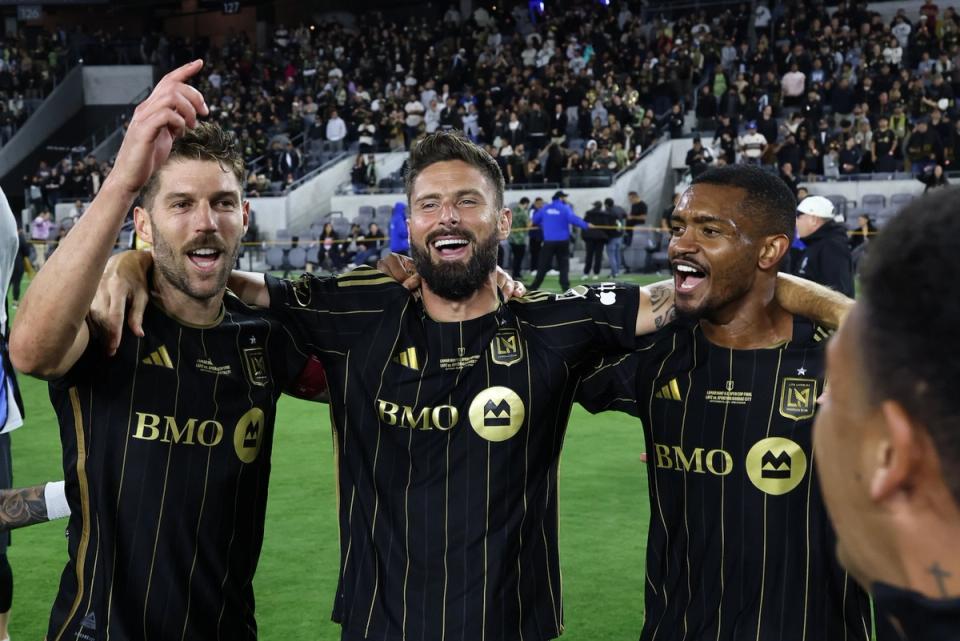 Olivier Giroud celebrates with his arms around two LAFC teammates