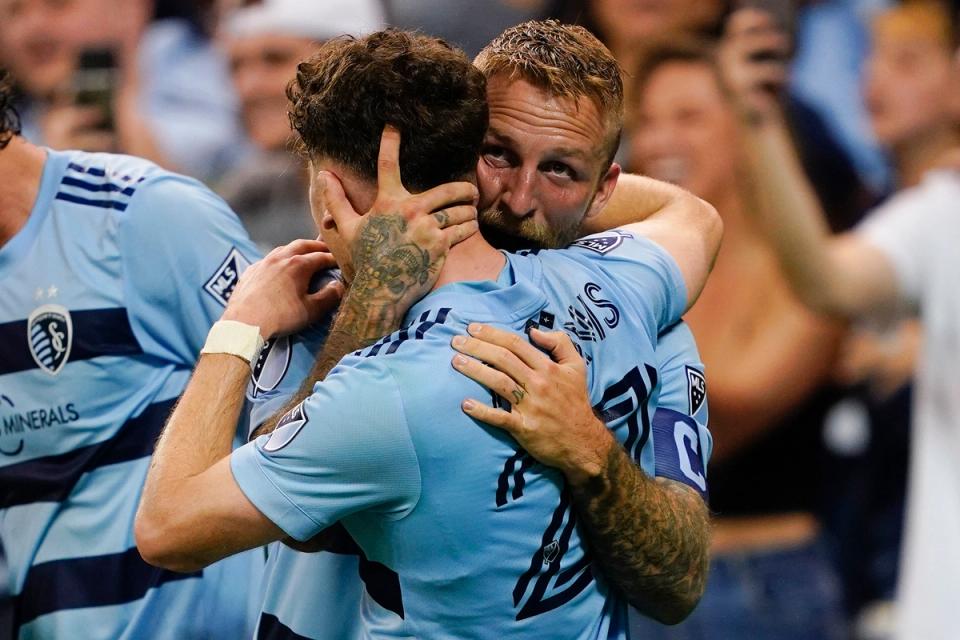 Russell embraces a teammate during an Open Cup match