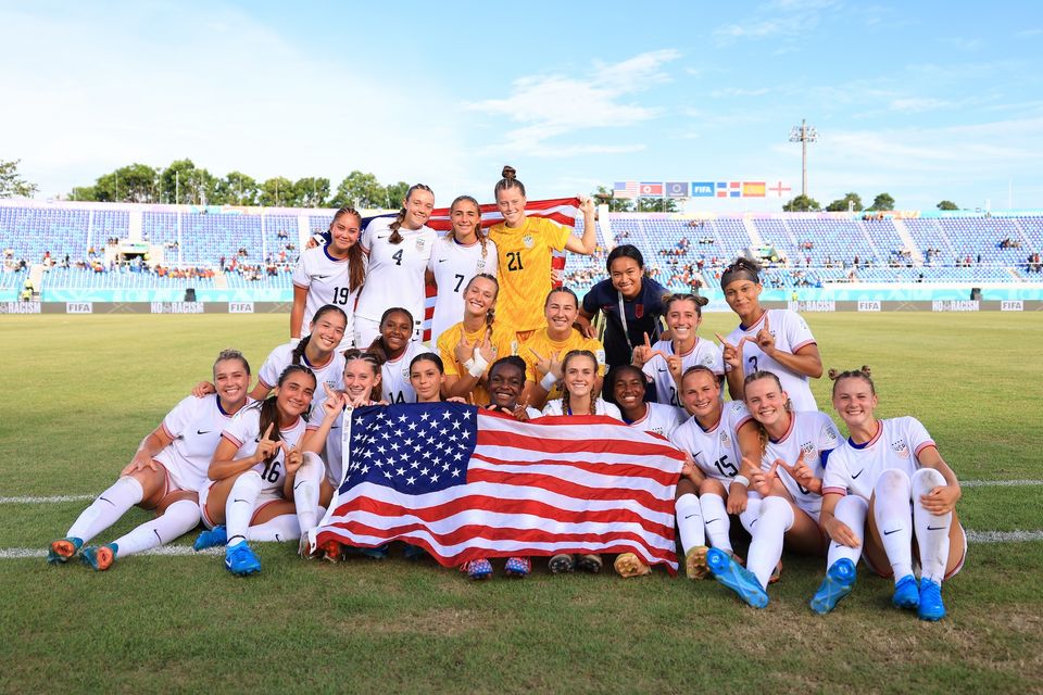 The U-17 WYNT celebrates winning third place on the field with a USA flag