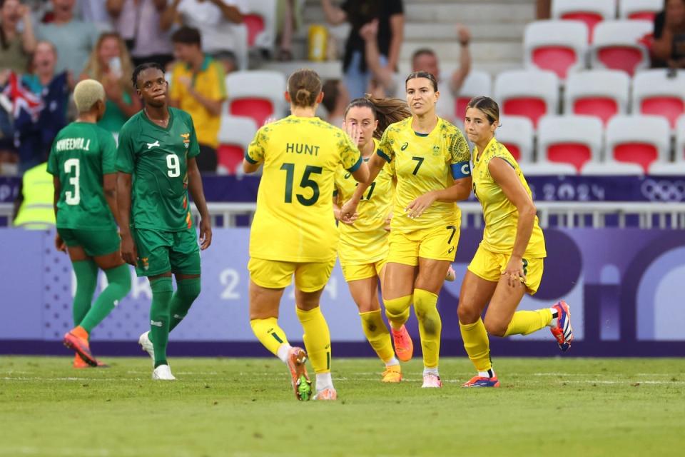 Members of the Australian National Team celebrate on the field during a match against Zambia