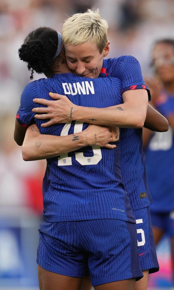 Crystal Dunn hugs Megan Rapinoe