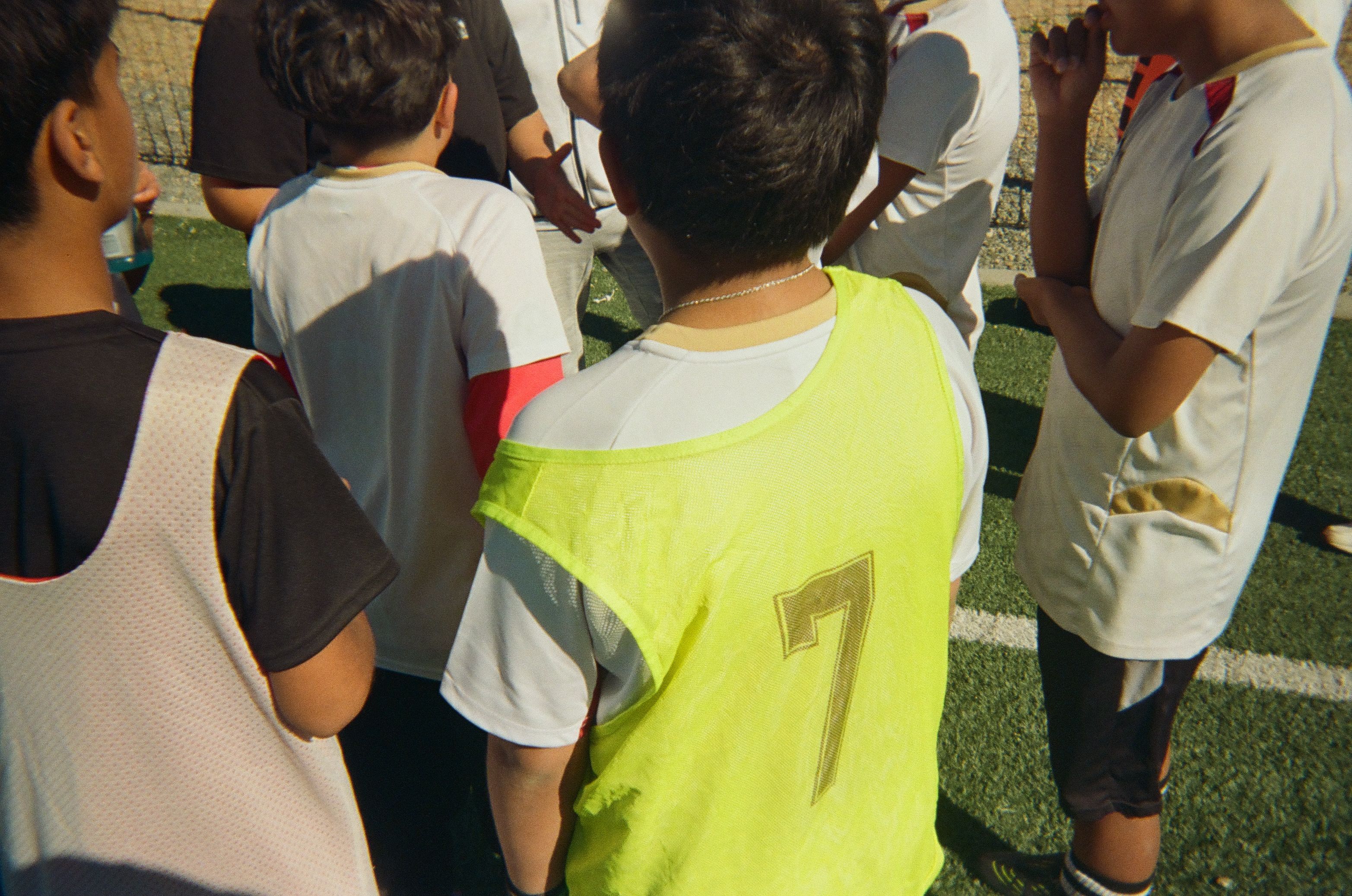 Young soccer players gathered together during a team discussion on the field.