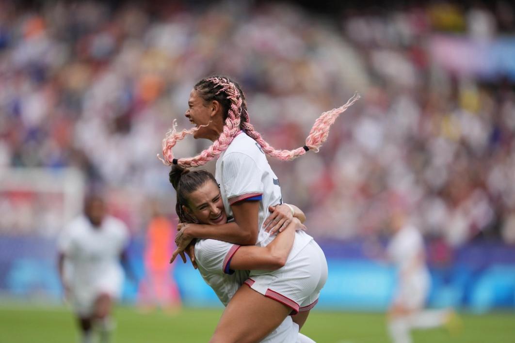 Trinity Rodman leaps into Emily Fox's arms in celebration of her goal against Japan in the Olympics