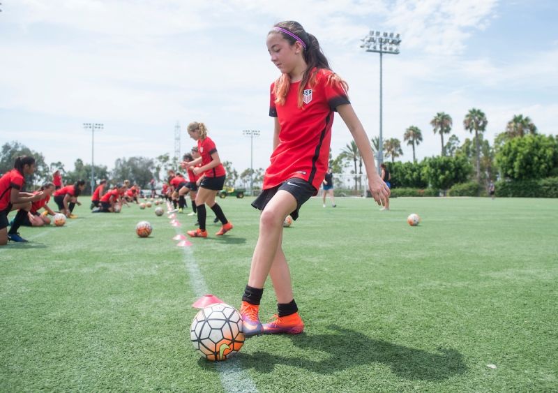A young girl participating in a soccer training session.