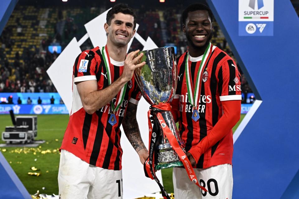 Christian Pulisic and Yunus Musah raise the Italian Super Cup trophy after winning it with AC Milan