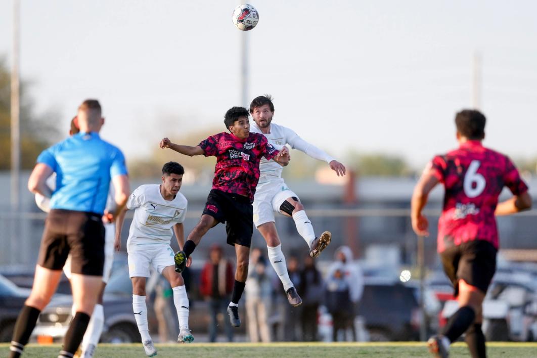 Tulsa Athletic fight for a header in a match