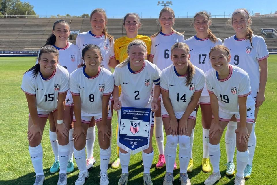 us u19 wynt starting 11 in white kits and white shorts holding a banner