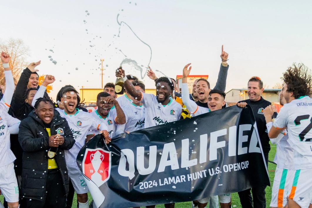 A photo of an amateur team holding a QUALIFIED 2024 Lamar Hunt U.S. Open Cup banner and celebrating