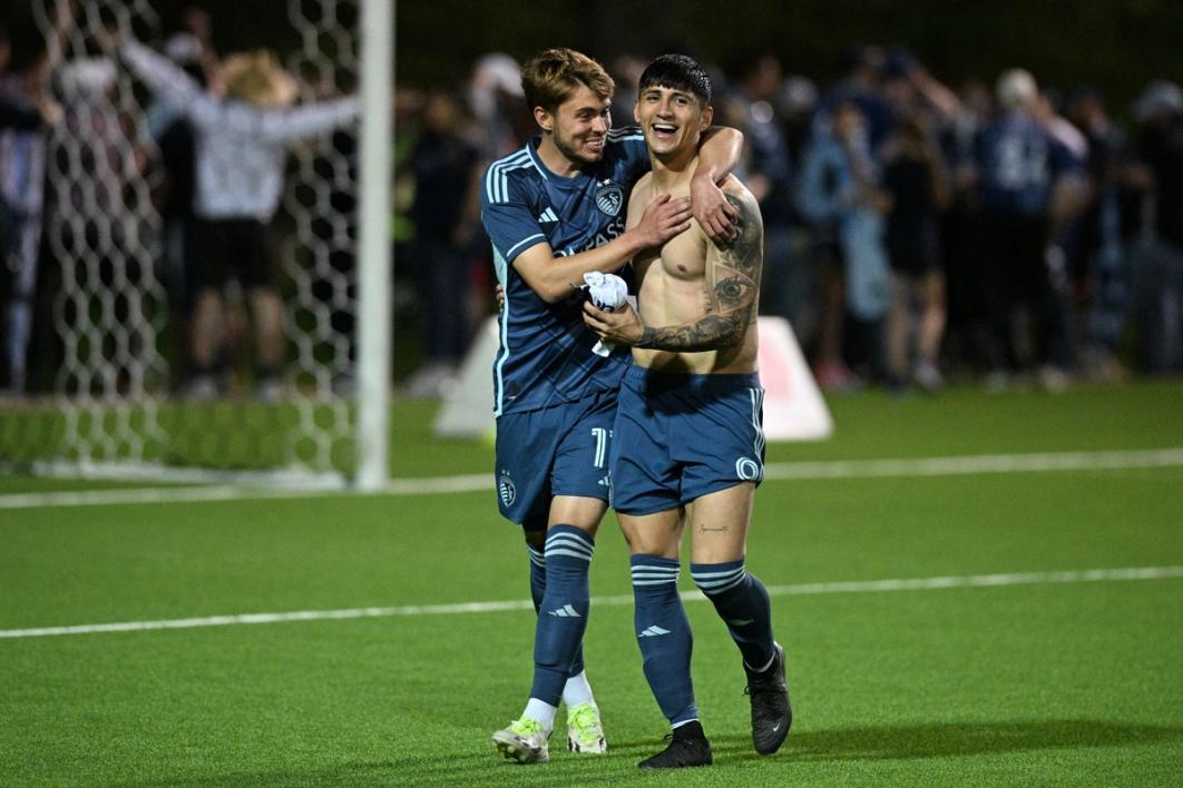 Two Sporting Kansas City players embrace on the pitch after a 2024 Open Cup match