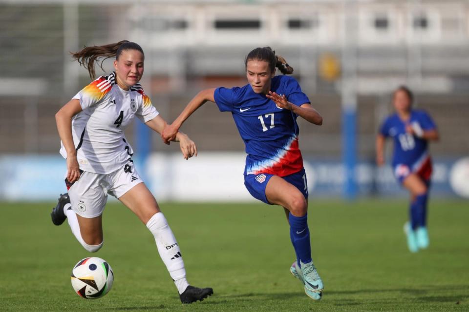 us number 17 in blue charges a ball against a german player