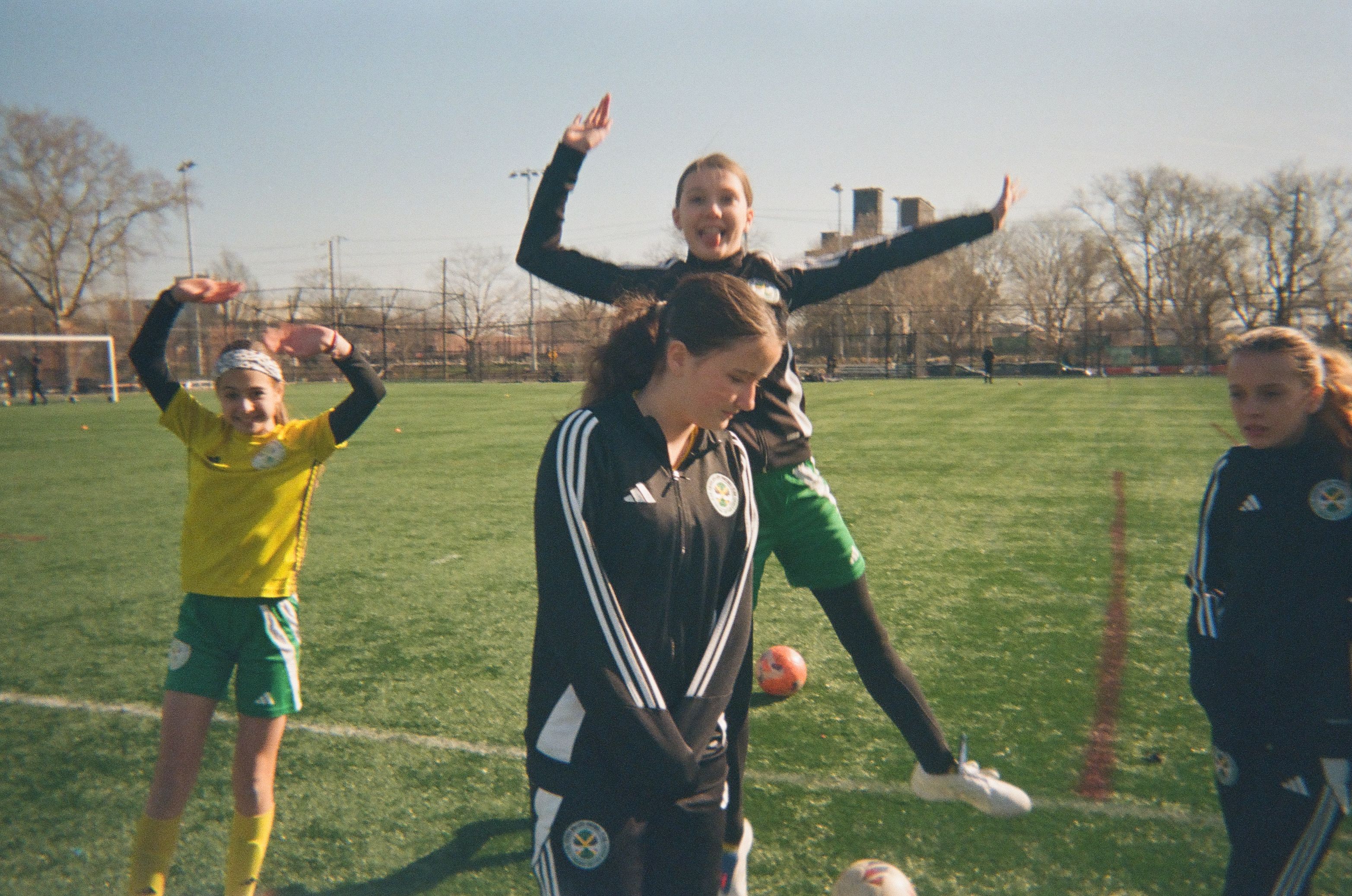 A group of girls posing for a photo at soccer training.