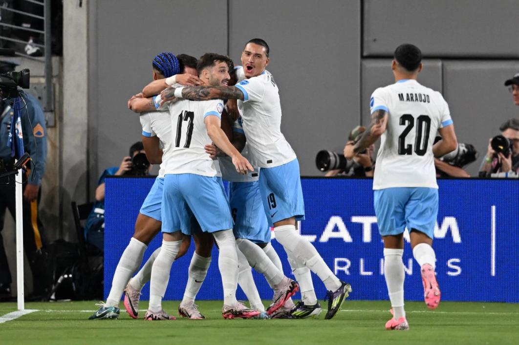 Six players on the Uruguay national team celebrate on the pitch