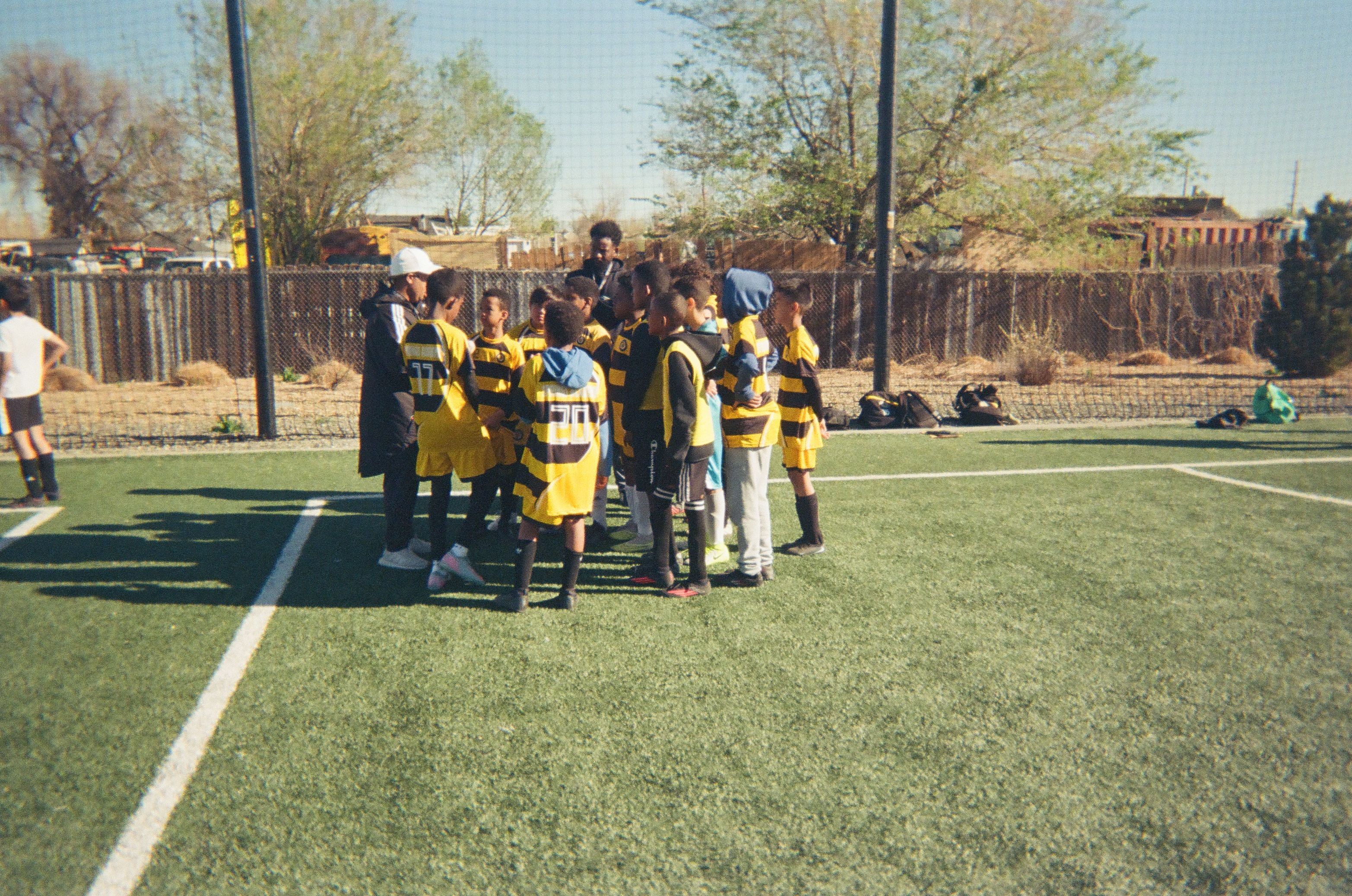 Youth soccer team gathered with coaches during a community soccer session.
