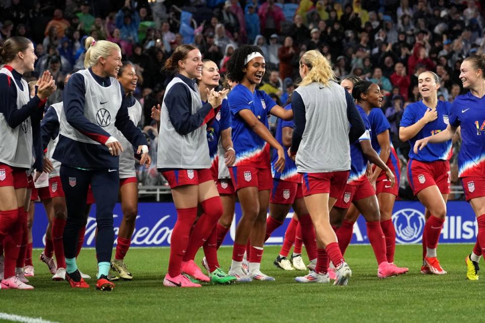 uswnt players in bibs celebrate with lily yohannes on the field