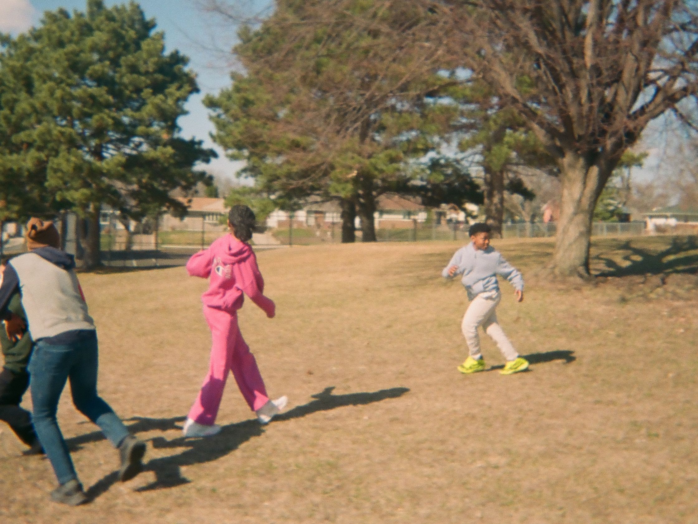 Kids playing soccer in a park.
