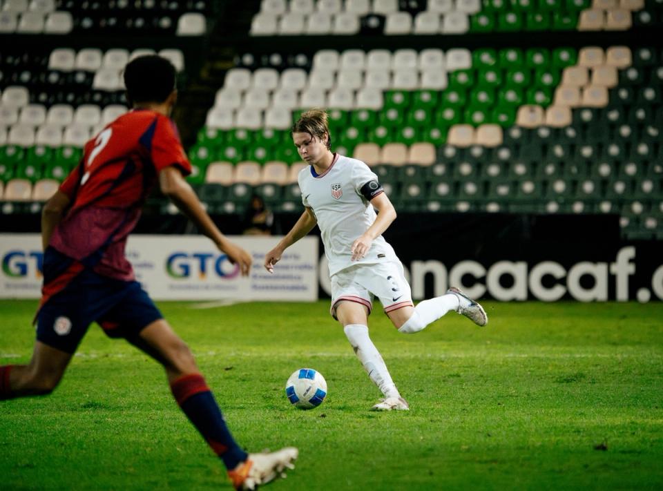 A U20 player dribbles the ball during a match