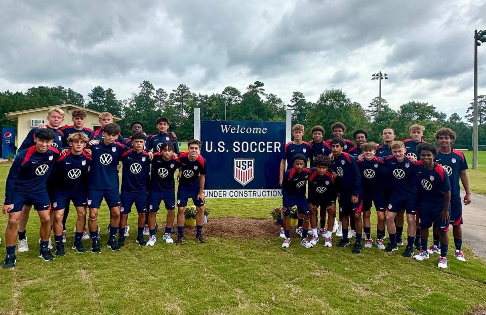 The U.S. U-16 MYNT around a sign that says Welcome U.S. Soccer Under Construction